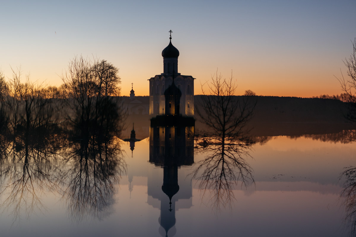 В прошлом году «маленькую Венецию» в Боголюбове нам застать не удалось из-за слишком теплой зимы. Зато в 2026-м луг у белокаменного шедевра знатно затопило вышедшими из берегов реками. В апреле, невзирая на погоду, пространство вокруг памятника заполнили ценители прекрасного: кто пешком, кто по воде.
